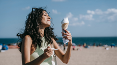 Image of woman on a beach with a melting ice cream cone