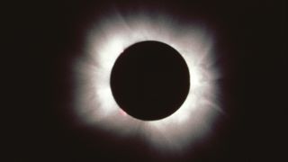 image of totality whereby the moon completely covers the sun and only the outer atmosphere shines bright white.