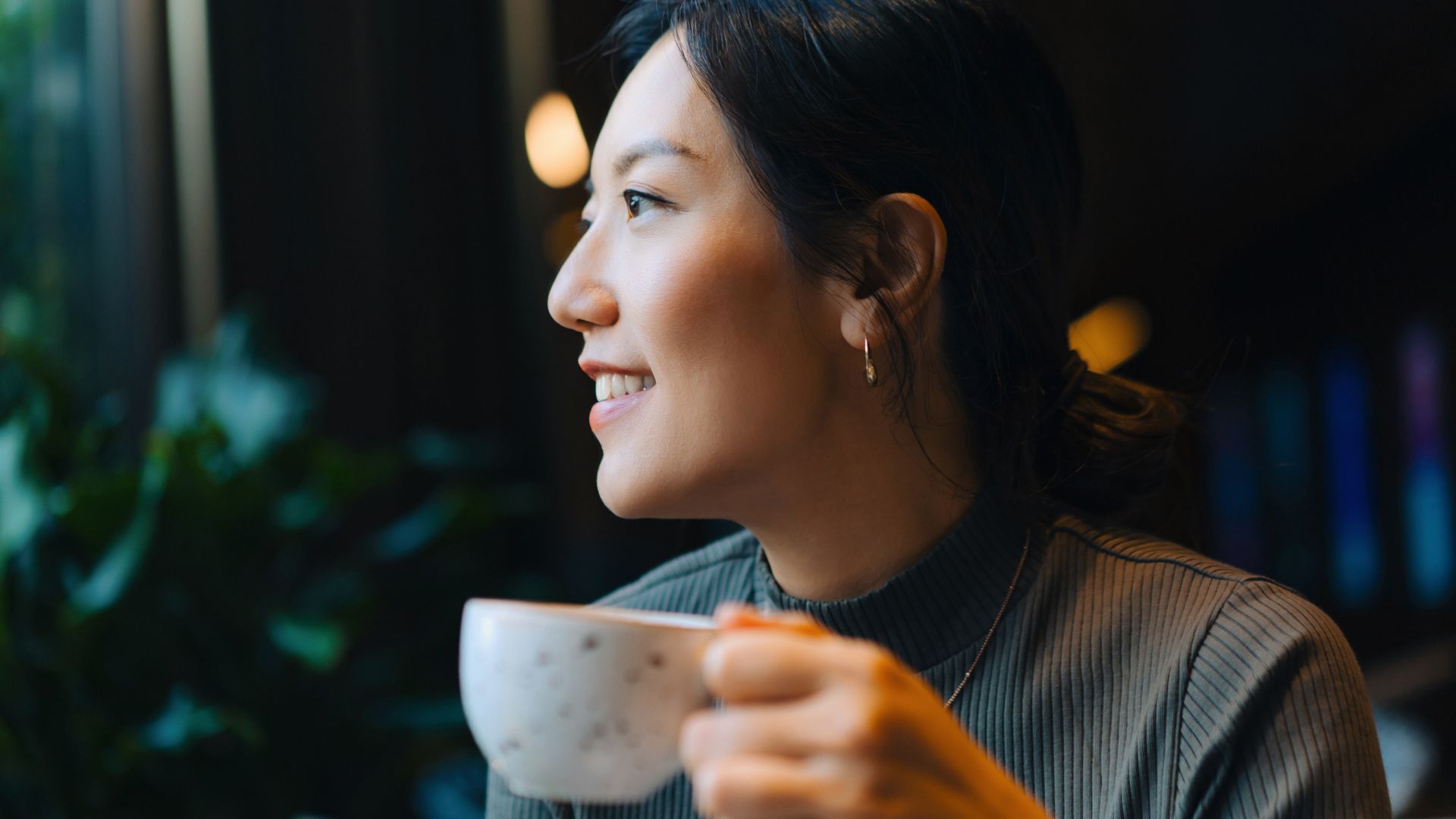 Woman doing Dry January sipping from a cup of hot tea, smiling