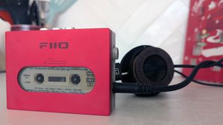 Fiio CP13 on a kitchen counter with headphones in the background