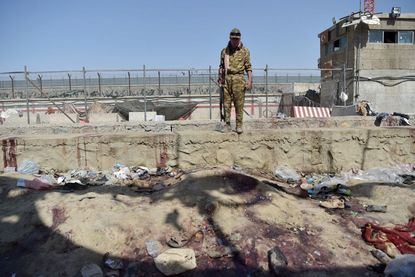 Taliban guard at Kabul airport bombing site
