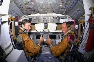STS-1 crewmates John Young and Bob Crippen give a 'thumbs-up' aboard the space shuttle Columbia's flight deck in 1981.