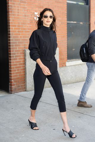 Bella Hadid walks in Manhattan wearing the capri pants trend and a matching black jacket