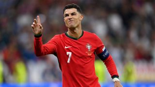 Cristiano Ronaldo raises his hand to celebrate scoring the first penalty in Portugal's shoot-out win over Slovenia at Euro 2024.