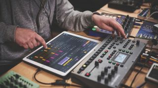 A DJ presses on an iPad running Apple Logic Pro for iPad