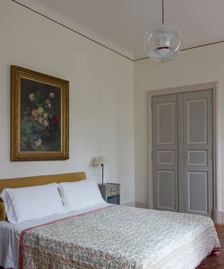 White bedroom, grey double doors, vintage bedspread, unique red painted ceiling trim