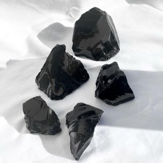 Black obsidian crystals on a white backdrop