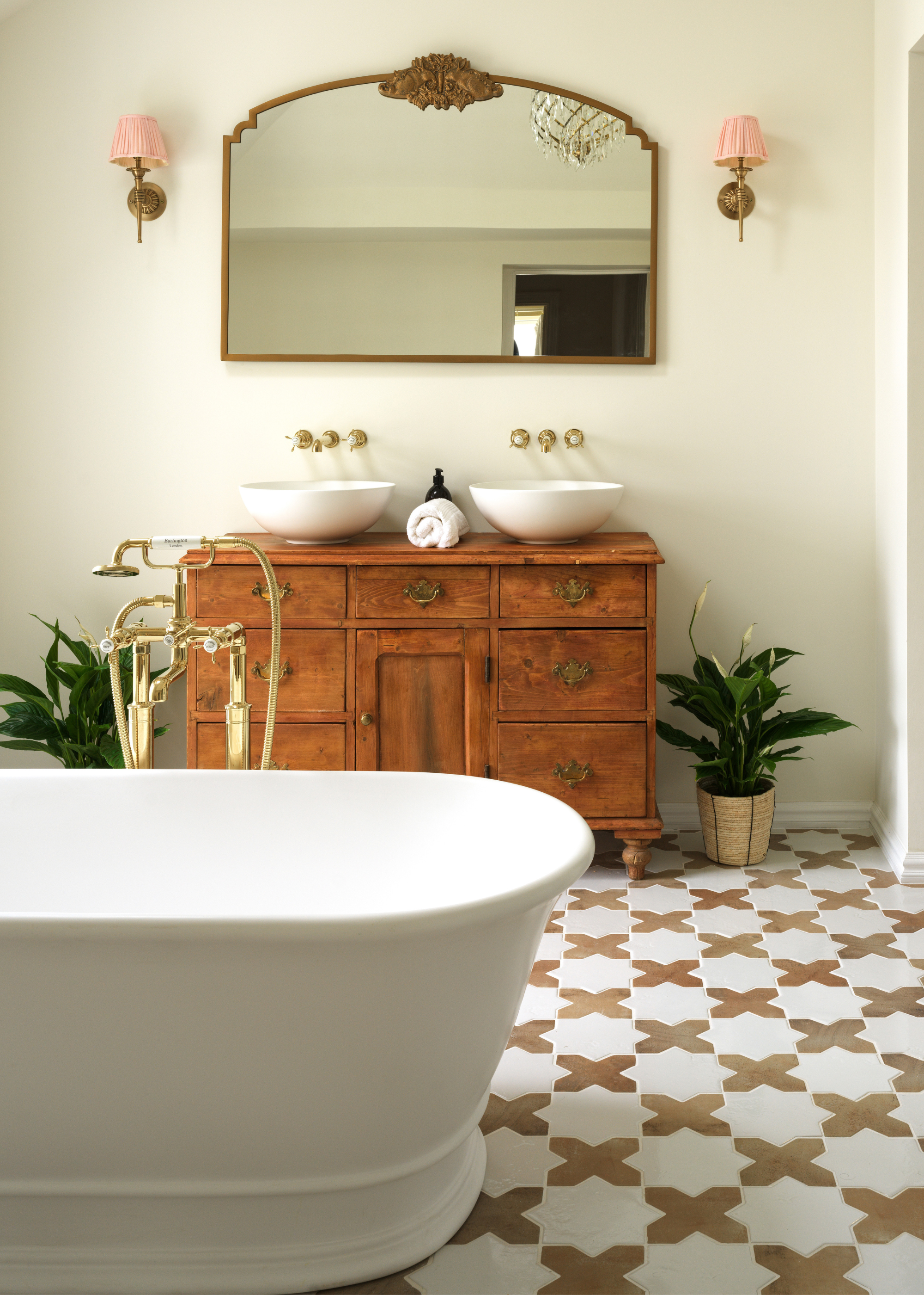 a grand bathroom with a free standing tub, wooden cabinet and tiles floor