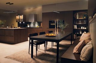 A brown kitchen diner with dim lighting and soft furnishings