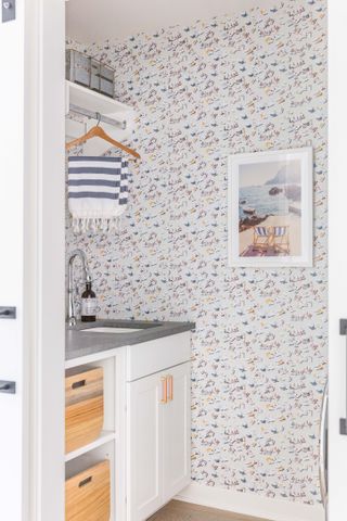 laundry room with shelving and colorful wallpaper