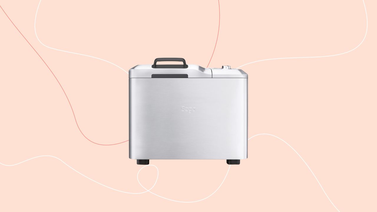 A stainless steel silver bread maker superimposed on a pink background 