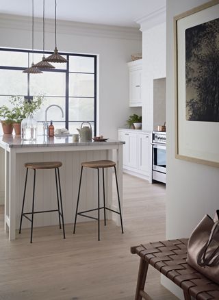 white kitchen with kitchen island/breakfast bar, pendant lights, wooden floor, marble countertop