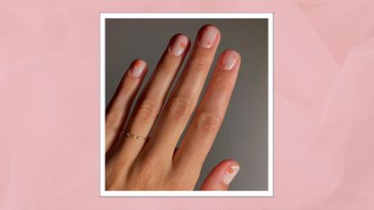 A close up of a hand with Spring Flower nails - the manicure features a nude base coat and tiny coral flower detailing - by nail artist @matejanova/Mateja Novakovic/ in a pink textured template