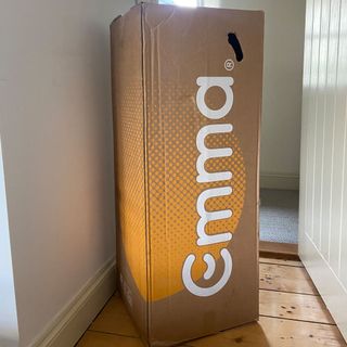 The Emma Hybrid Original mattress being tested in a bedroom with a wooden floor