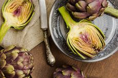 Fresh cut purple artichokes in oriental bowl closeup background