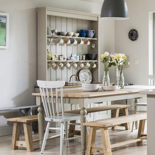 dresser with table and chair and white wall