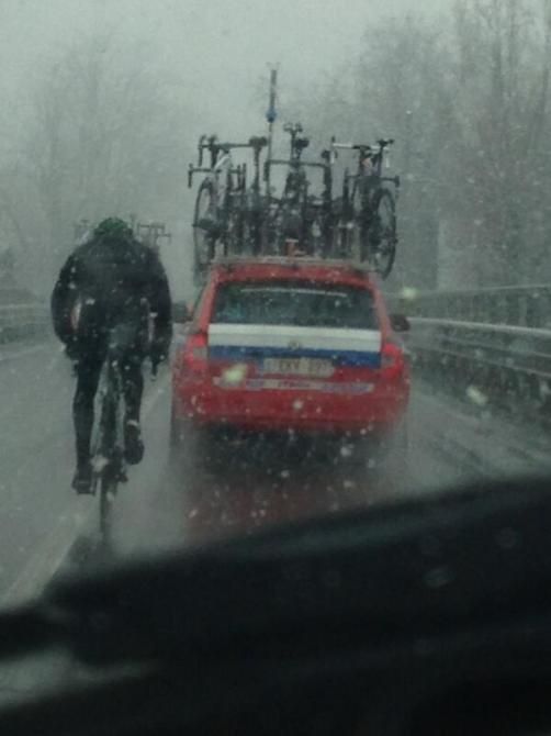 A rider tucks in behind the Katusha car