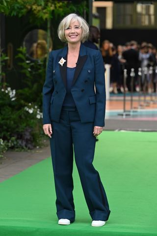 Emma Thompson wearing a navy suit and trainers