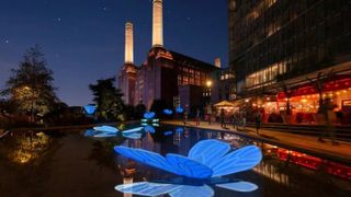 Battersea Power Station Light Festival: illuminated blue butterfly artwork on water, with power station in background