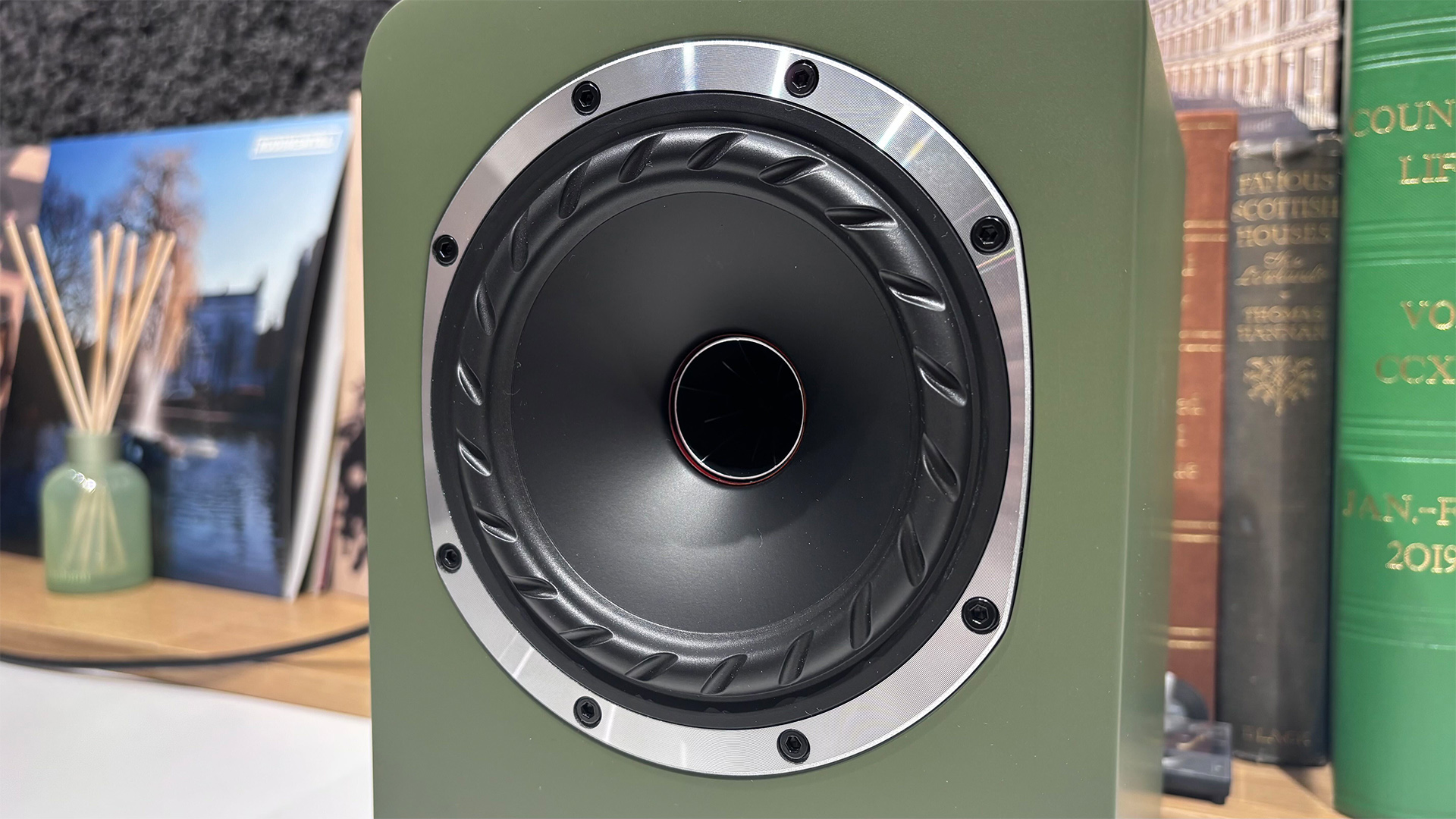 Fyne Audio Cubitt 5 speakers in olive green finish, placed on white table with records in background