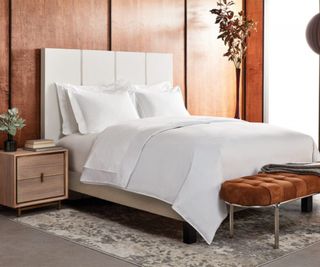 Sofitel Signature Bedding Collection on a bed against wood-panelled walls.