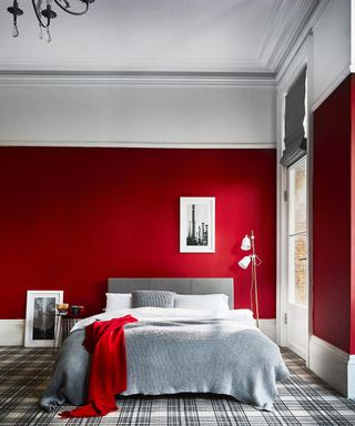 Red bedroom with grey bed and grey plaid patterned carpet