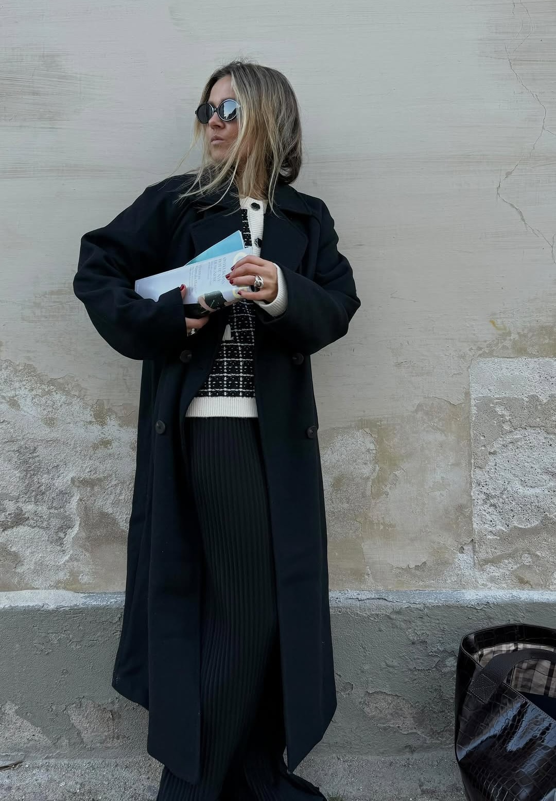 Camilla in a black coat with a slouchy tote