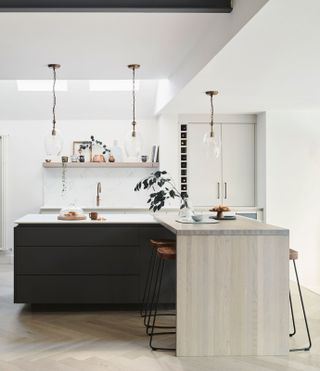 a kitchen with a trio of glass pendant lights across a stepped ceiling