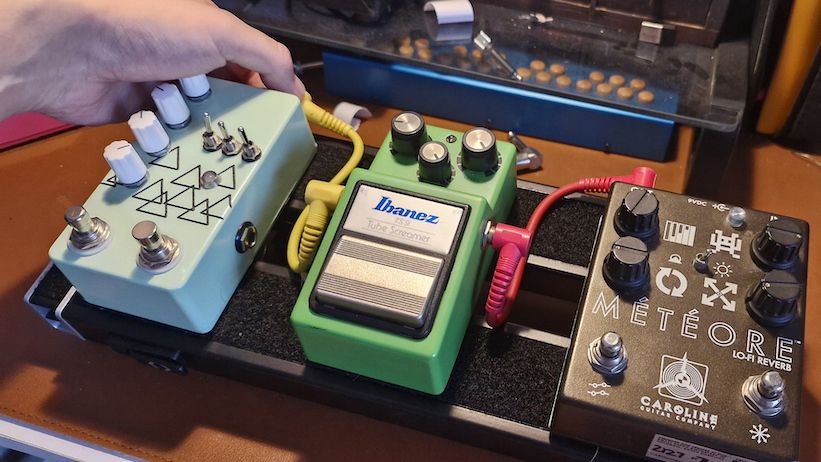 Close up of a D'Addario XPND1 pedalboard with pedals attached