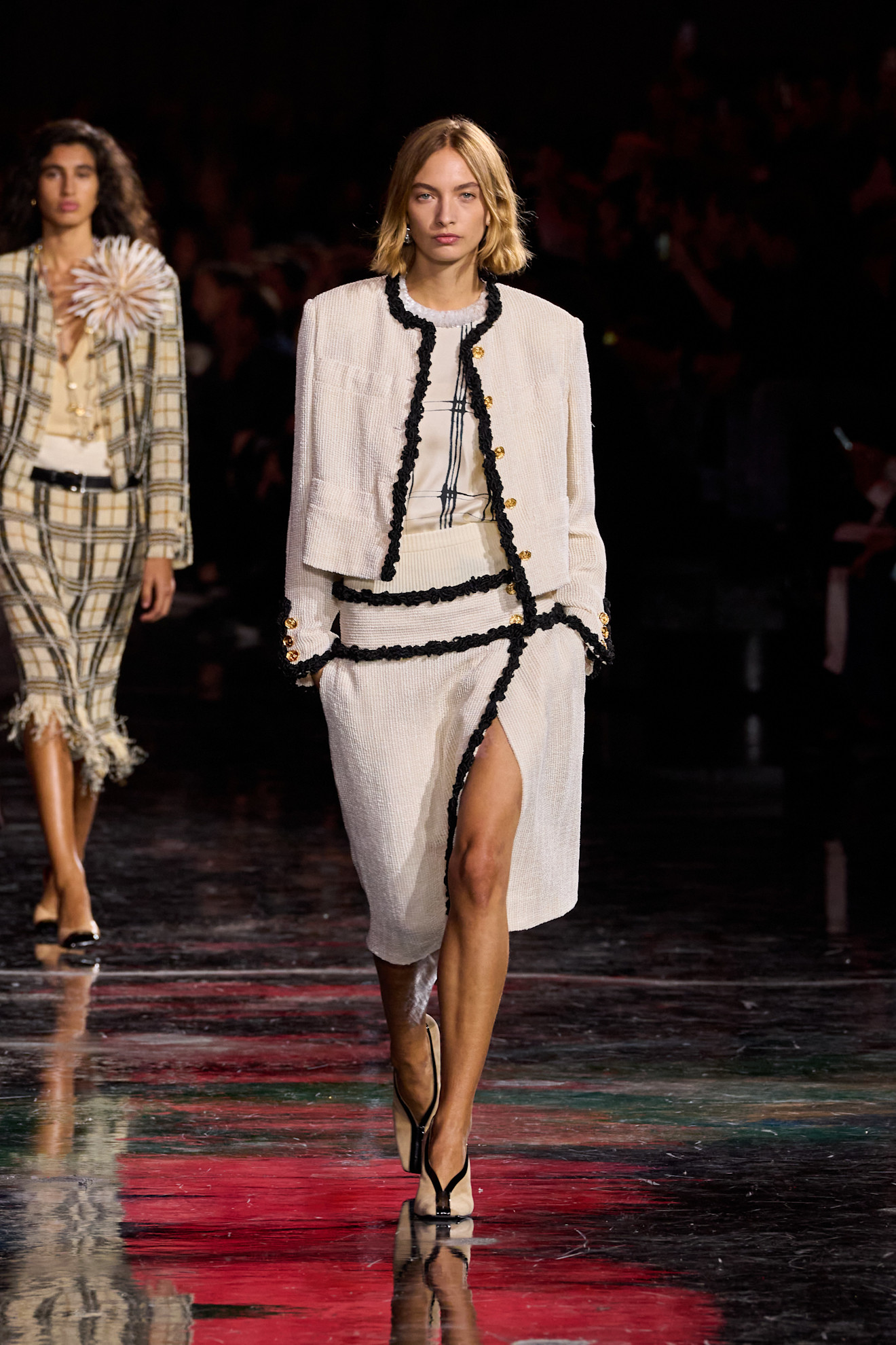 a model at Chanel Spring 2026 wearing a white lady jacket, white tweed skit, and white plaid shirt