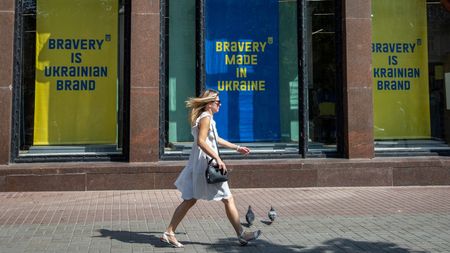 A woman walks past large ‘Bravery is Ukrainian brand’ adverts in central Kyiv