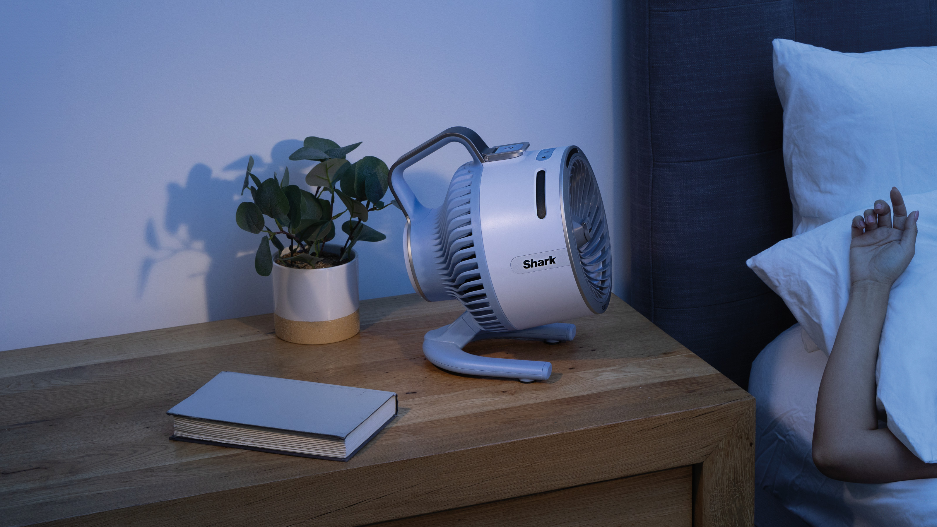 shark flexbreeze hydrogo fan in white on a bedside table in a bedroom