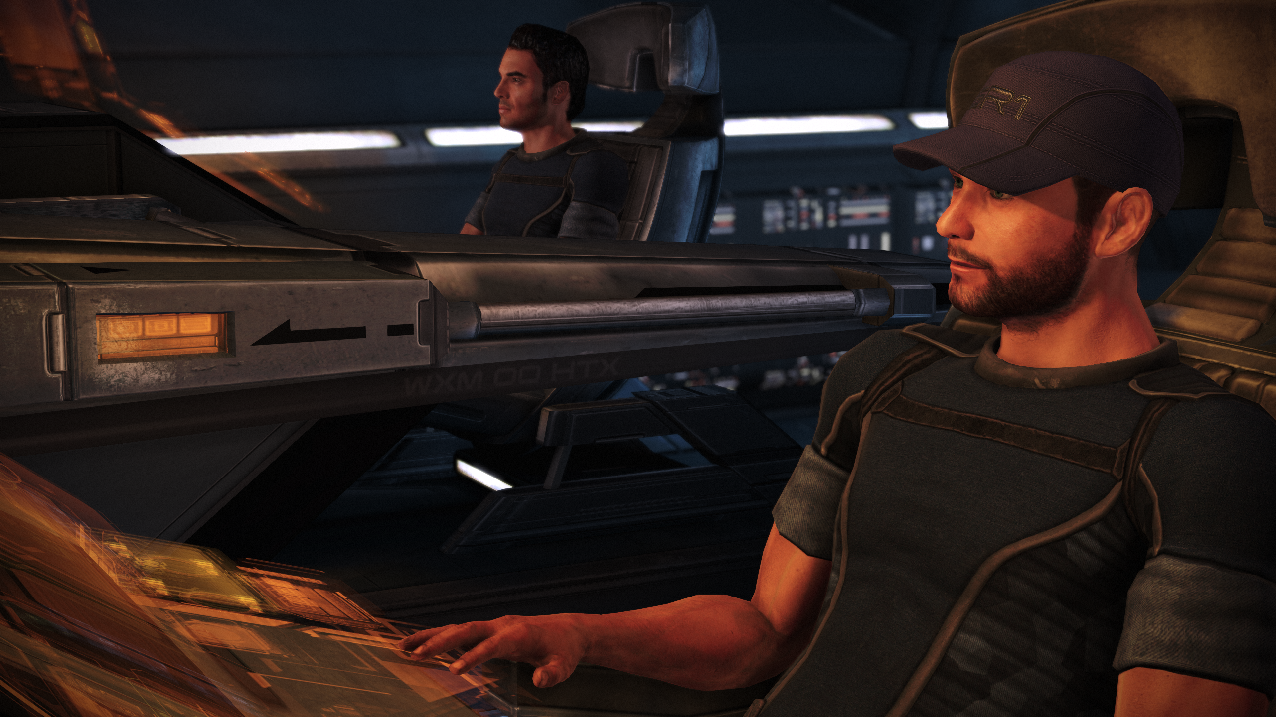 A man sitting at a sci-fi spaceship console with a hand casually placed on the touch controls. It's Joker, Mass Effect's snarky pilot.