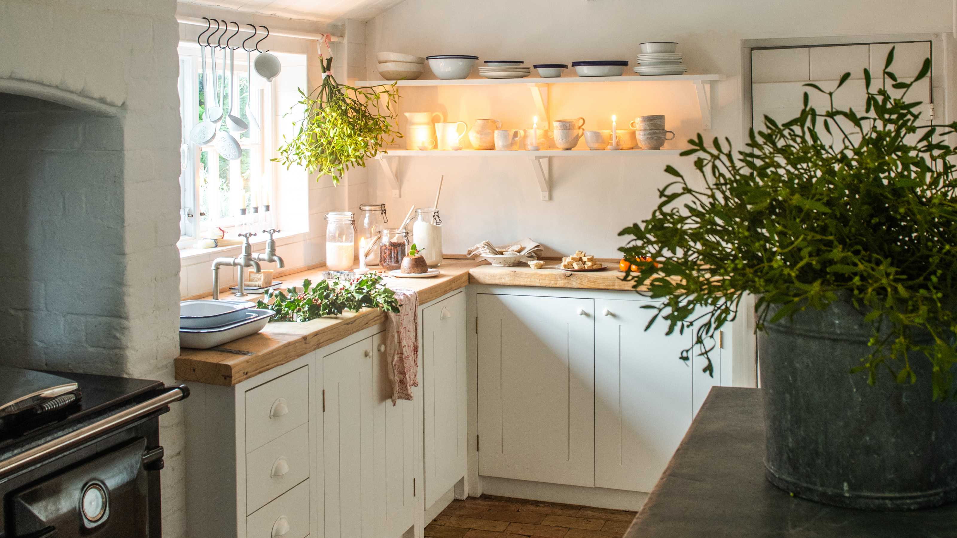 neutral kitchen with cream cabinets and wooden worktops dressed for christmas with mistletoe and festive foliage 1