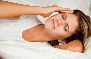 woman-headache-bed