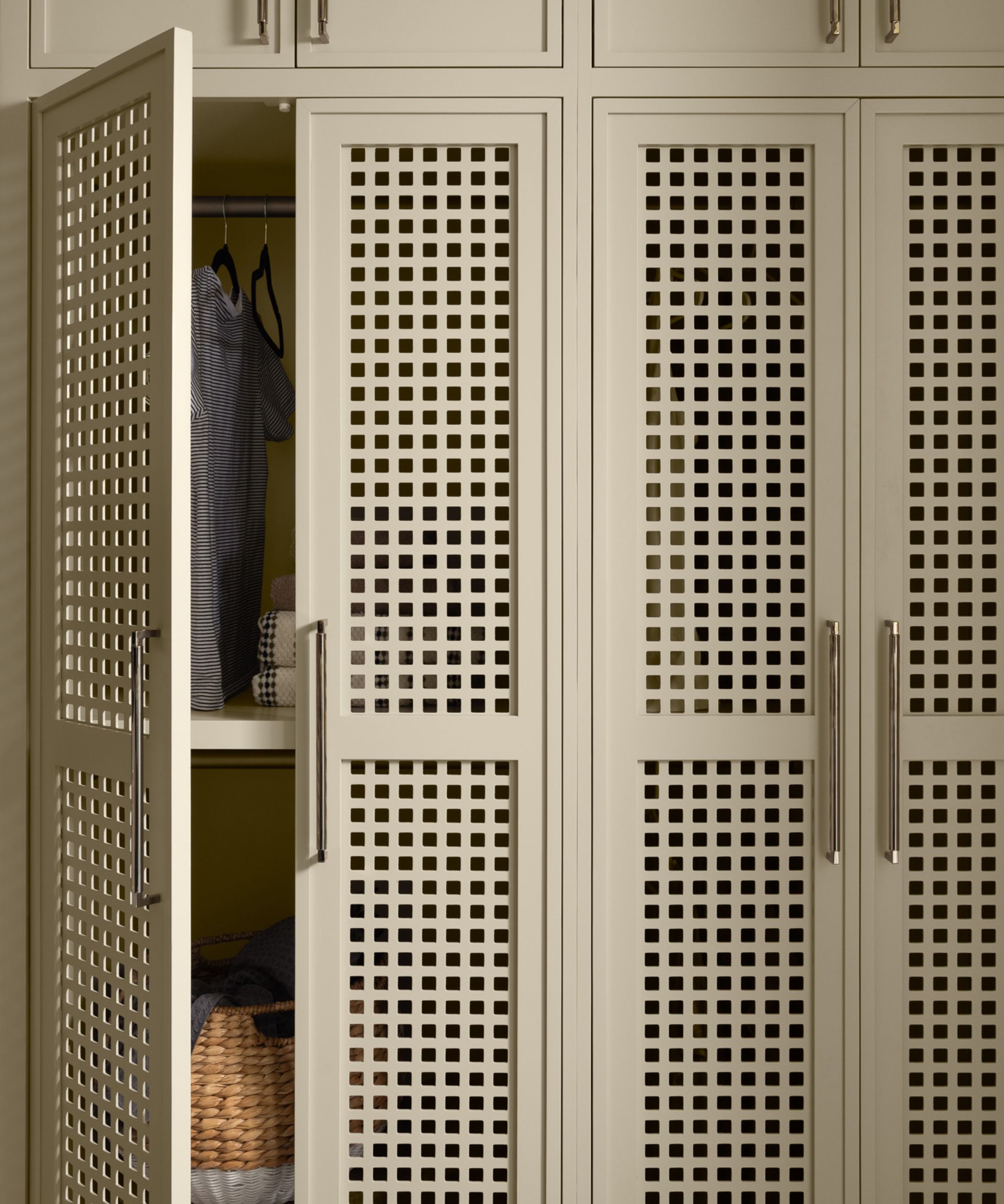 Built-in wardrobes with carved doors and gold handles, painted in Benjamin Moore's Manchester Tan.