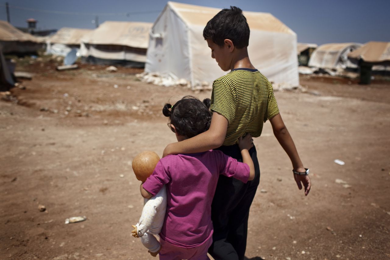 Syrian refugee children walk in the Bab al-Salam refugee camp in Syria&amp;#039;s northern city of Azaz on July 15, 2013. Five thousand people a month are dying in the Syria war which has now thrown u