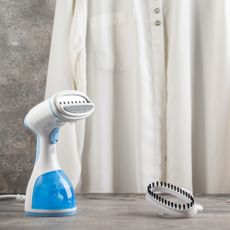 Handheld clothes steamer on tabletop