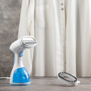 Handheld clothes steamer on tabletop