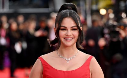 Selena Gomez wearing a red ball gown and diamond necklace on the emilia perez red carpet