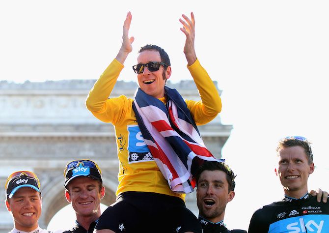 Bernhard Eisel (Team Sky) helps hold aloft 2012 Tour de France winner Bradley Wiggins