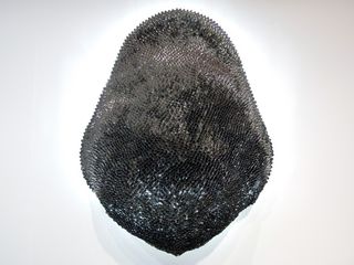 View of the '6302 Spoons' sculpture by Najla El Zein - a dark sculpture that resembles the skin of a reptile