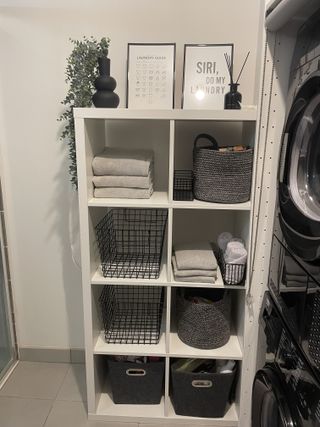 An original white IKEA kallax shelving unit housing clean folded laundry