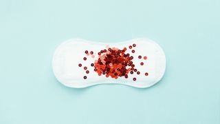 Red glitter on a period pad, representing heavy periods after 40