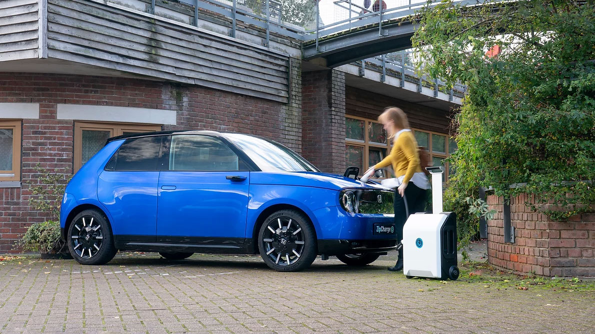 Woman plugging the ZipCharge Go into an EV