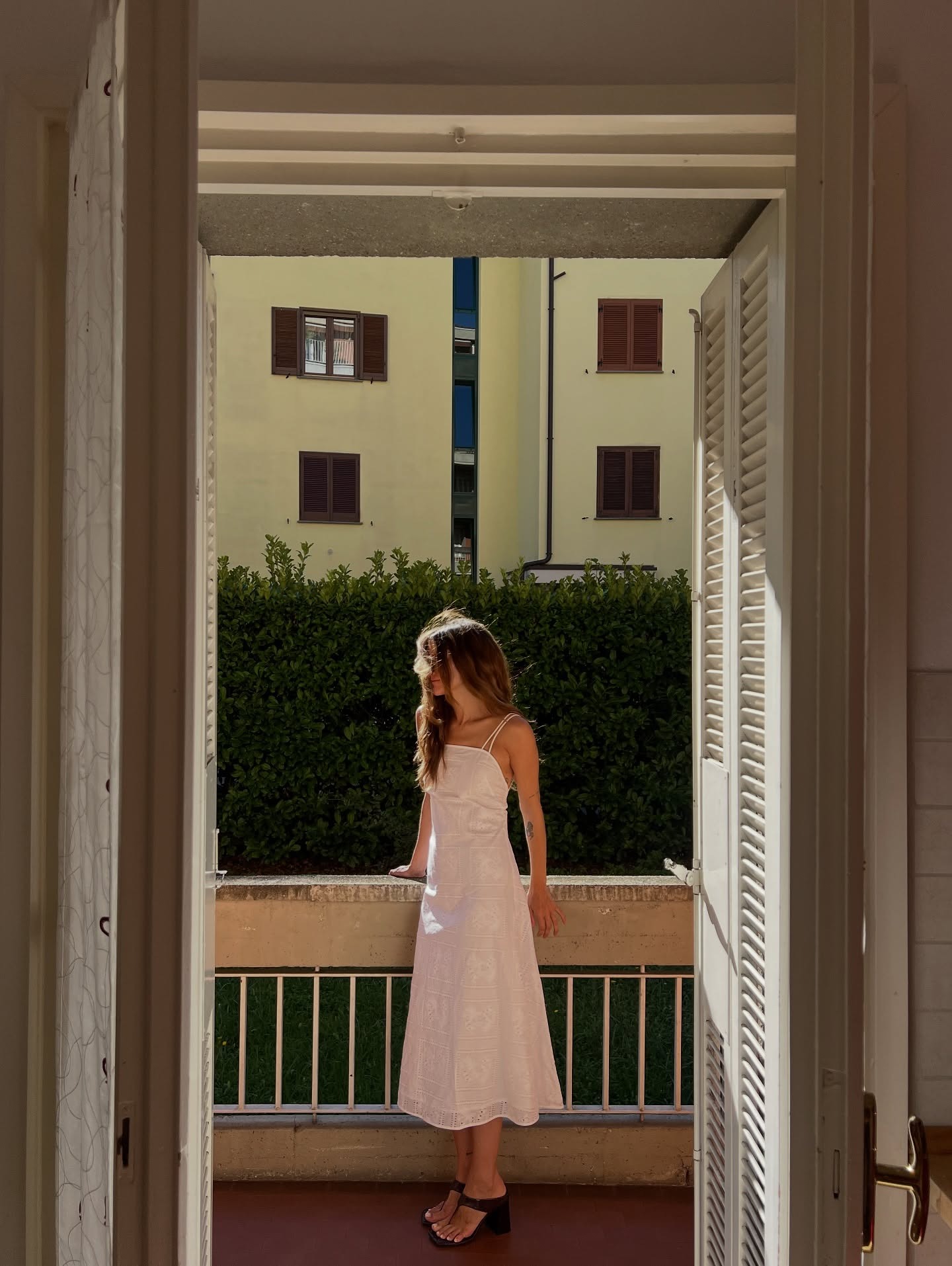 Eliza Huber wearing a white dress with stretch thong sandals.