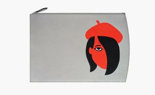 A light grey purse with a silhouette drawing of a woman's face on it in red and black.