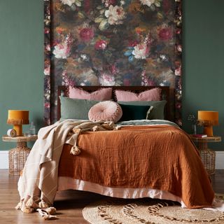 bedroom with floral wallpaper bed with designed cushions and yellow lamp