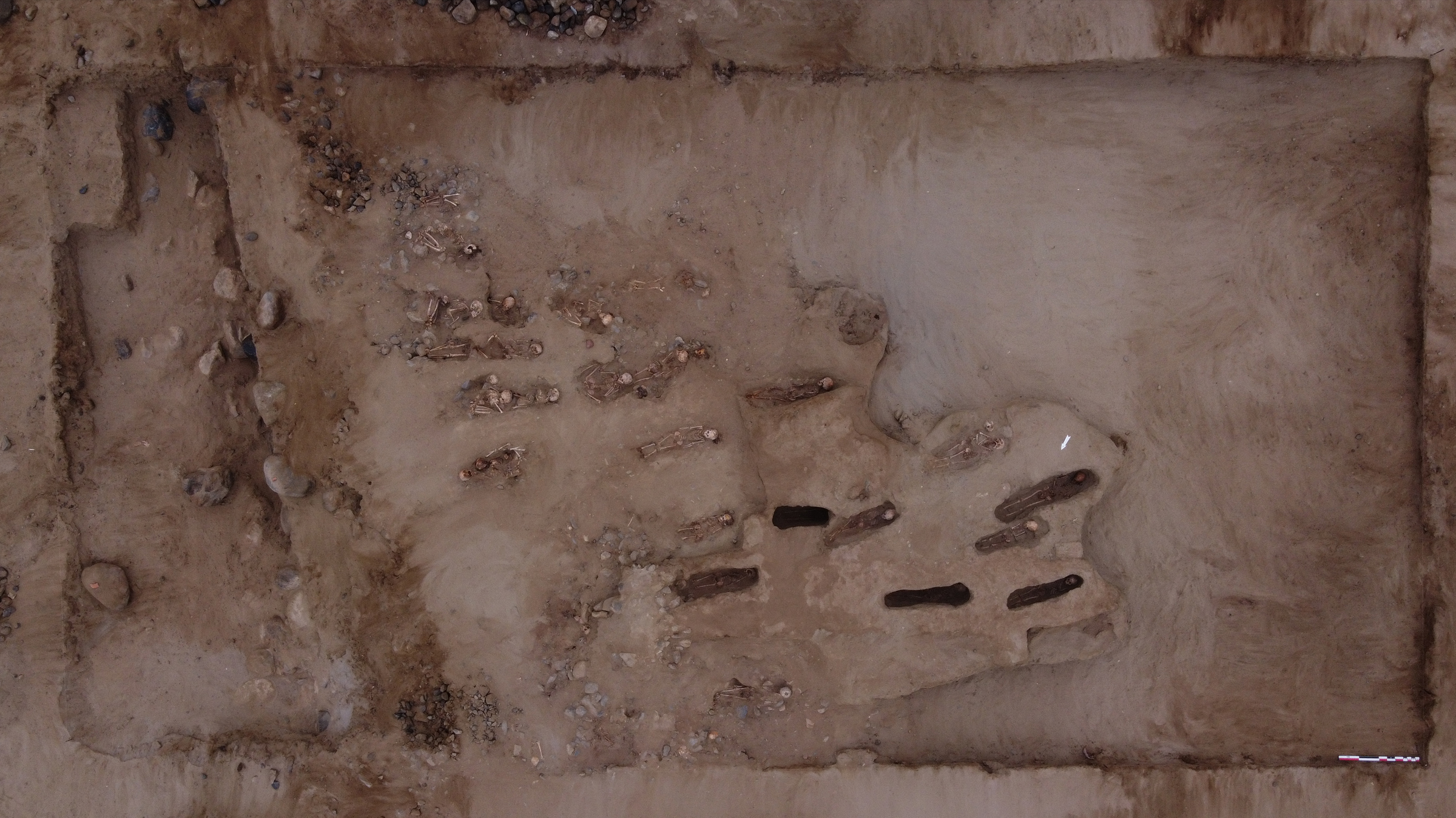 A panoramic view of the burial site in Peru showing human skeletons.
