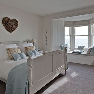 bedroom with double bed with cushions and window seating
